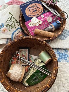 two baskets filled with sewing supplies on top of a table