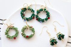 four pairs of beaded christmas wreath earrings on a plate