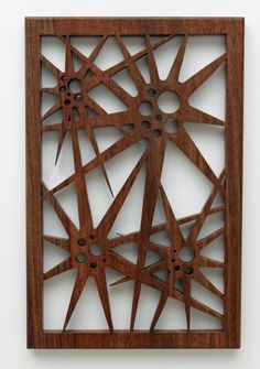 a wooden wall hanging on the side of a white wall