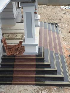 the stairs are lined with different colored rugs and wood steps leading up to a house