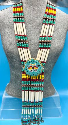 Bone hairpipes and crystal beads are often seen as part of traditional Native American dancers.  This modified breastplate  has been created to proudly proclaim that this is a good day to be Indigenous . It is designed to be worn not only in the dance circle, but in mainstream life, showing your Native pride and fashion sense.   The necklace is 10 vertical strands of bone hairpipes, nickel beads and 8mm sparking, faceted, fire-polished glass crystal green- turquoise , cranberry, tangerine and ye Bone Jewellery, Indigenous Jewelry, Bone Bead Necklace, Breast Plate, Native American Jewellery, Loom Designs, Turquoise Butterfly, Native Wears, Stone Bead Jewelry