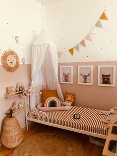 a child's room with a bed, rugs and pictures on the wall