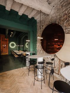 an empty restaurant with tables and stools in the center, surrounded by stone walls