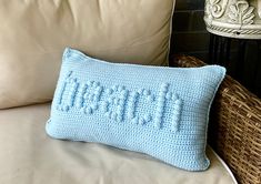 a blue crocheted pillow sitting on top of a couch