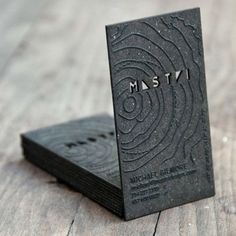 a business card sitting on top of a piece of black paper with the word msty printed on it