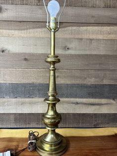 an old fashioned brass lamp on a wooden table