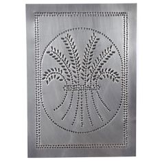 a square metal plate with an intricate design on the front and sides, in silver