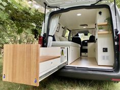 the interior of a van with its doors open and wood flooring in front of it