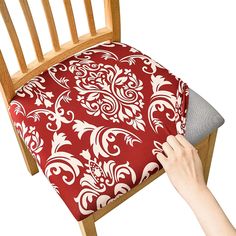 a hand is holding the back of a chair cushion