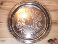 a silver plate sitting on top of a wooden table