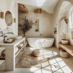 a white bath tub sitting inside of a bathroom next to a sink and toilet under a window