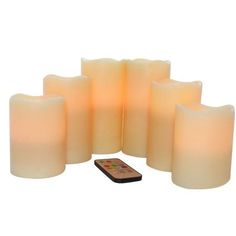 six lit candles and a cell phone on a white background