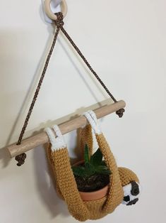 a stuffed slotty hanging from a wall with a plant in it's mouth