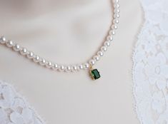 Romantic Style Emerald Necklace, Wedding Swarovski Pearl and Emerald CZ Bridal Choker, Green Emerald  Vintage Pearl Necklace Materials used: - White/Ivory Cream Swarovski pearls - cubic zirconia stones - gold plated over brass The necklace will arrive packaged ready for gift giving in a delicate white jewelry box with a silver ribbon. Matching earrings for this necklace:  Back to my shop http://www.etsy.com/shop/crinadesign73 Thank you for visiting my store! Green Pearl Necklace, Vintage Pearl Necklace, Emerald Green Stone, Pearl Necklace Vintage, Bridal Choker, Silver Ribbon, White Jewelry Box, Stone Choker, Bride Accessories