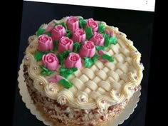 a cake decorated with pink roses and green leaves