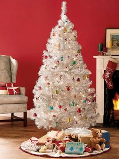 a white christmas tree with presents under it