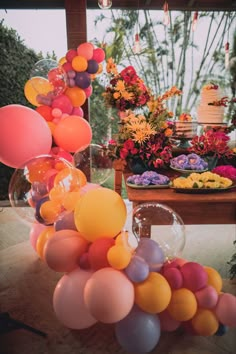 a table with balloons and flowers on it