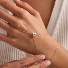 This beautiful hand chain is crafted from sterling silver and features a dainty chain. The centerpiece of the chain showcases a stunning heart-shaped zircon gemstone, exuding a casual yet sophisticated vibe. Show off your romantic side (without being cheesy) with this delicate design. Metal: 925 sterling silver Finish: 18k gold Gemstone: white zirconia Bracelet length: adjustable with 4 cm extender (1.5") Chain: cable link Clasp: spring ring Hypoallergenic, nickel-free Don’t forget, proper care Adjustable Diamond Jewelry For Valentine's Day, Valentine's Day Adjustable Diamond Jewelry, Adjustable Heart-shaped Diamond Jewelry, Heart-shaped Chain Jewelry For Weddings, Elegant Adjustable Heart Bracelet With Cubic Zirconia, Elegant Adjustable Cubic Zirconia Heart Bracelet, Elegant Cubic Zirconia Heart Bracelet Gift, Adjustable Heart-shaped Cubic Zirconia Jewelry, Adjustable Heart Cut Cubic Zirconia Jewelry