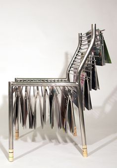 a chair made out of metal strips and magazines