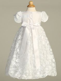 Details This beautiful tulle Christening gown has an embroidered skirt with a floral satin ribbon pattern and a bow accent at the waist. Short puff sleeves with a dainty ribbon bow. Comes with a matching embroidered bonnet. This gown is perfect for a Baptism, Christening, Blessing or any other Special Occasion. Available sizes: X-Small (0-3 months), Small (3-6 months, Medium (6-12 months), Large (12-18 months) 100% Polyester Hand wash cold. Do not use bleach. Hang dry. Made in the USA by Lito Ch Embroidered Bonnet, Tulle Bodice, Baptism Gown Girl, Ribbon Pattern, Baptism Gown, Christening Gown, First Communion Dresses, Baptism Dress, Baptism Girl