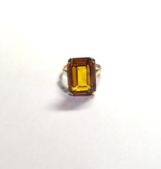 Large Yellow Emerald Cut Rectangle Citrine Gemstone 4 Prong Solitaire Ring Size 9 Metal: 10k yellow gold, (acid tested) Weight: 7.2 grams Ring Size: 9 (can be resized upon request) Size: Sits 10mm off finger, 2mm shank Stone: 18.50 x 13.50mm emerald cut rectangular citrine gemstone Hallmarked: makers mark November birthstone This is an estate piece in excellent pre-loved condition. Please see pictures for reference. Gold Solitaire Ring With Rectangular Stone, Yellow Gold Rings With Rectangular Accent Stones, Yellow Citrine Topaz Ring Rectangular Shape, Rectangular Topaz Ring In Yellow Gold, Classic Yellow Faceted Rings, Rectangular Yellow Gold Topaz Ring, Classic Yellow Topaz Ring With Emerald Cut, Classic Yellow Emerald Cut Topaz Ring, Classic Emerald Cut Yellow Topaz Ring