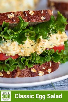 a close up of a sandwich on a plate with lettuce and tomato slices