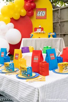 a lego themed birthday party with balloons and tableware on the table, along with decorations