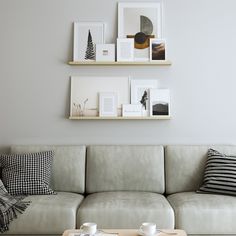 a living room with two couches, coffee table and pictures on the wall above them