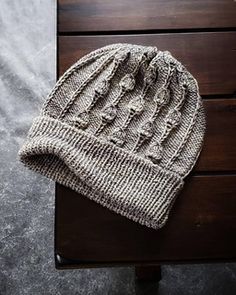 a knitted hat sitting on top of a wooden table