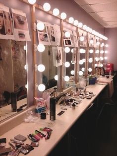 a long counter with many mirrors and lights on it, all lit up by bulbs