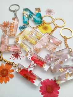 a bunch of different colored glass items on a white surface with flowers in the foreground