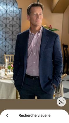 a man standing in front of a table wearing a blue jacket and pink shirt with the words recherche visuele on it