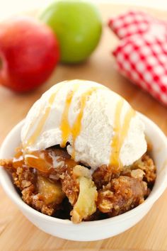 a bowl filled with ice cream next to an apple and another fruit on the table