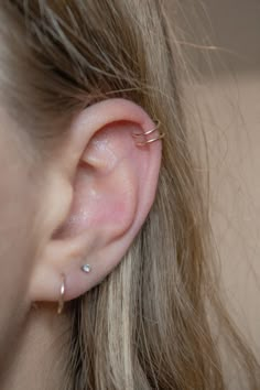 a close up of a person's ear with two piercings on the side