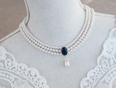 Vintage Style Bridal Necklace, Swarovski Pearls and Blue Sapphire CZ Bridal Choker,Something Blue CZ Multi Row Vintage Pearl Bridal Necklace Materials used: - White/Ivory Cream Swarovski pearls - cubic zirconia stones - rhodium plated over brass clasp The necklace will arrive packaged ready for gift giving in a delicate white jewelry box with a silver ribbon. Matching earrings for this necklace:  https://www.etsy.com/ca/listing/571295845/bridal-earrings-cubic-zirconia-blue Back to my shop http://www.etsy.com/shop/crinadesign73 Thank you for visiting my store! Bridal Statement Necklace, Black Velvet Choker, Custom Initial Necklace, Bridal Pearl Necklace, Pearl Drop Necklace, Contemporary Necklace, Bridal Choker, Necklace Swarovski, White Jewelry Box