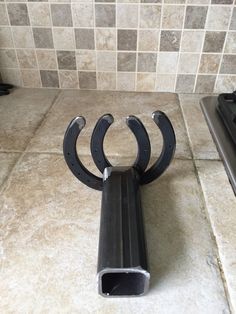 a metal object sitting on top of a tile floor next to a stovetop oven