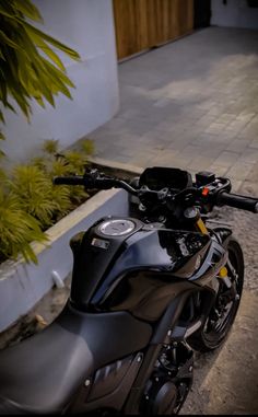 a black motorcycle parked next to a planter