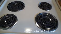 four black burners on top of a white stove