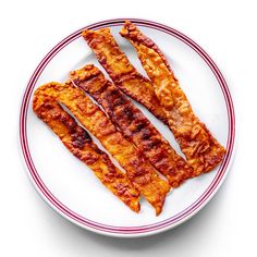 bacon strips on a white plate with red trim around the edges and in between them