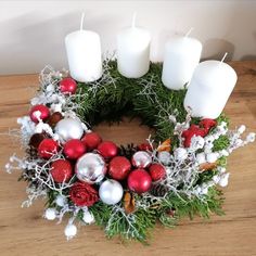 a wreath with white candles and red ornaments