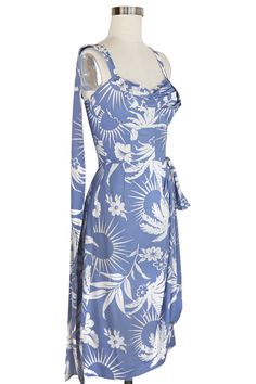 Our Lena Sarong Dress was created using several different 1940s and 50s sarong dresses combining to make the perfect shape! This version is made without the back elastic so the bust has a more structured shape in the flat rayon (no bra needed!) Pleated Sweetheart Shelf Bust Adjustable Halter Neck or Straps Back Dramatic Drape at Shoulder Sarong-style Faux-Wrap Skirt Knee-length to Below-Knee Fabric: Flat Rayon A collection for summer travels filled with laughter, joy, and unforgettable experiences. Bon voyage! This wedgewood blue 1940s novelty palm print is recreated in our dresses and separates that are easy to wear seaside or citywide. Add pops of red and rattan for vintage tropical vibes or pair with white for a perfectly posh polish! Traditional Summer Sarong For Vacation, Traditional Summer Vacation Sarong, Traditional Printed Sarong For Summer, Summer Floral Print Sarong Beachwear, 1930 Summer Dress, 40s Skirt, Floral Print Sarong Beachwear, Camilla Dress, Sarong Dress