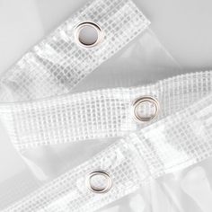 two pieces of white sheer fabric with silver rings on each side and the other end