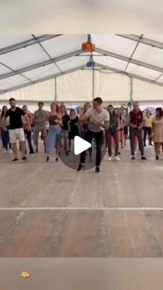 a group of people are dancing in a tent