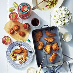 some fried food is sitting on a table next to other dishes and utensils