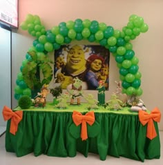 a green table topped with balloons and pictures