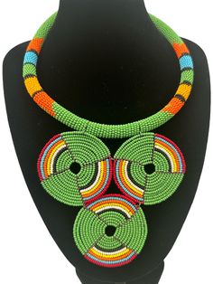 This stunning African necklace showcases a beautiful green beaded disc pendant that is truly authentic. The pendant is handcrafted and features intricate beading detail that is sure to impress. The necklace is perfect for those who appreciate the fine craftsmanship and unique jewellery. The beaded pendant is eye-catching and adds a touch of elegance to any outfit.  The diameter of the pendant - 5 inches. Neck Width - 16 inches. Intricate Beading, African Necklace, Beaded Pendant Necklace, Disc Pendant, Beaded Necklaces, Beaded Pendant, Favorite Jewelry, Unique Jewellery, Necklace Etsy