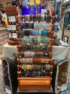 an assortment of bracelets are on display in a jewelry store with other items behind it