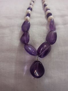 Amethyst Necklace Smooth AAA Tumble Beads With Center Tumble Gemstone 20 inch Necklace Stone : Natural Amethyst Fresh Water Pearl Shape :- Tumble Size :- 7x7-14x18mm 1. Weight :- 237 carat With Amethyst Tumble, 20 INCH Necklace Polish :- Handmade Purity :- 100% Natural Gemstone color - white blue It is known as the 'love stone' as the message it emits is the strong vibration of unconditional love, joy, warmth and healing. As quartz crystals are profound amplifiers of energy, it may help to kindl Necklaces For Jewelry Making With Polished Tumbled Beads, Purple Polished Beads Necklace As Gift, Handmade Purple Rondelle Necklaces, Purple Polished Beads Necklace For Gift, Purple Necklace With Round Stone Beads, Purple Natural Stone Beads For Gifts, Purple Natural Stone Beads For Gift, Purple Necklaces With Round Stone Beads, Purple Necklace With Round Stones