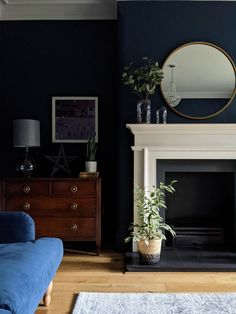 a living room filled with furniture and a fire place in front of a blue wall