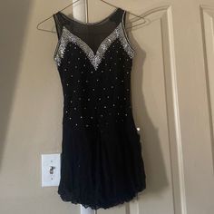 a black dress hanging on a door with beads and sequins all over it